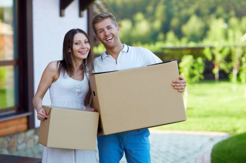 Professional movers carrying belongings from a Queens Park property